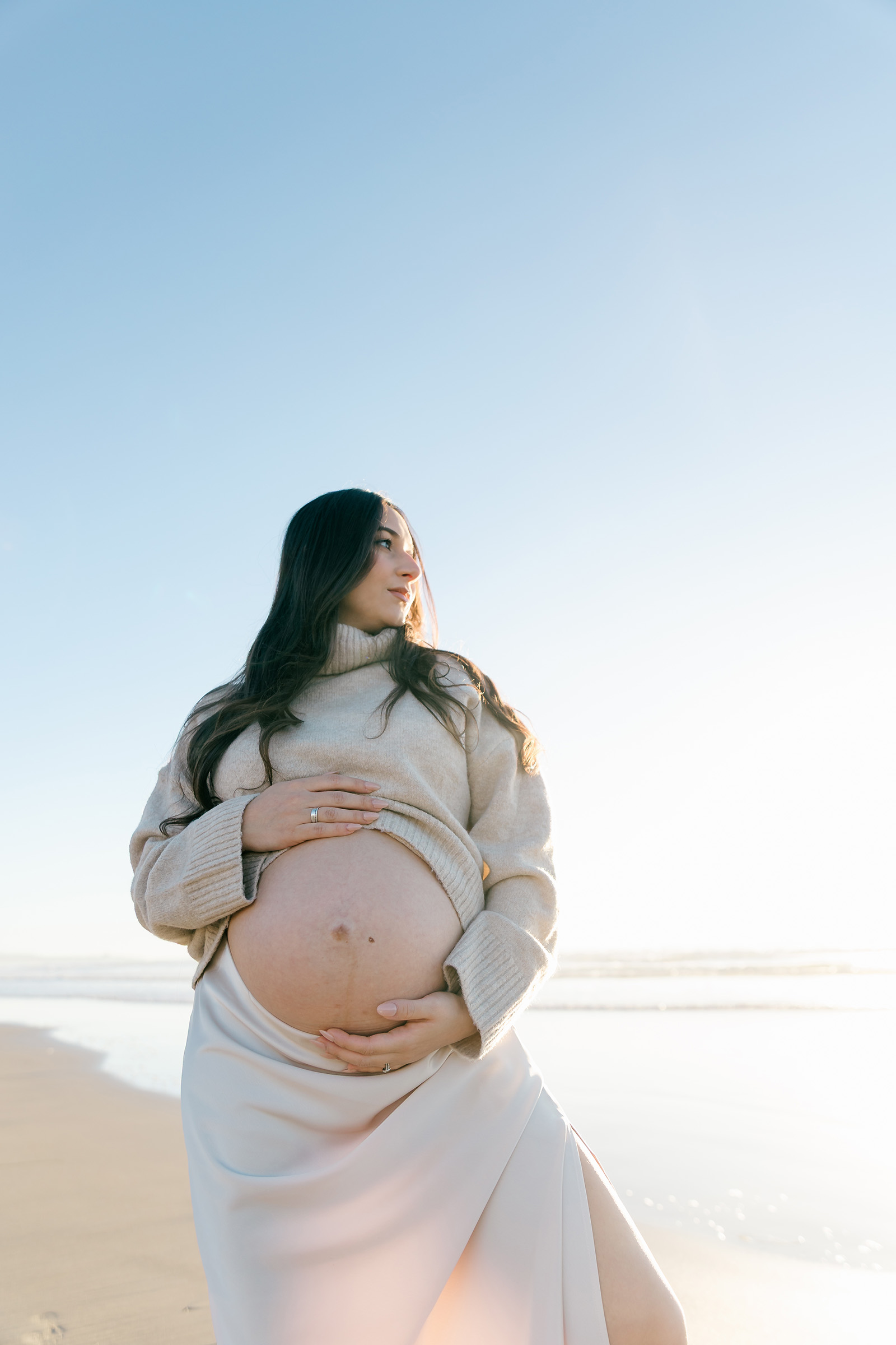 Expectant mother holding her belly during a maternity session in San Diego