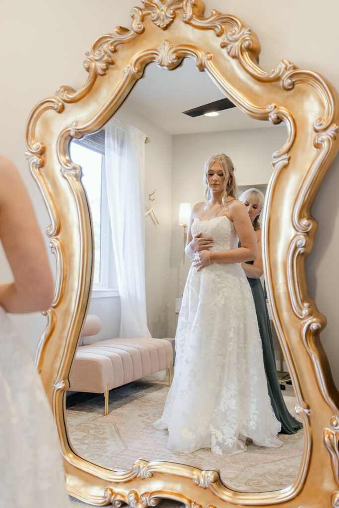 Mother of the bride helping to button up the wedding dress