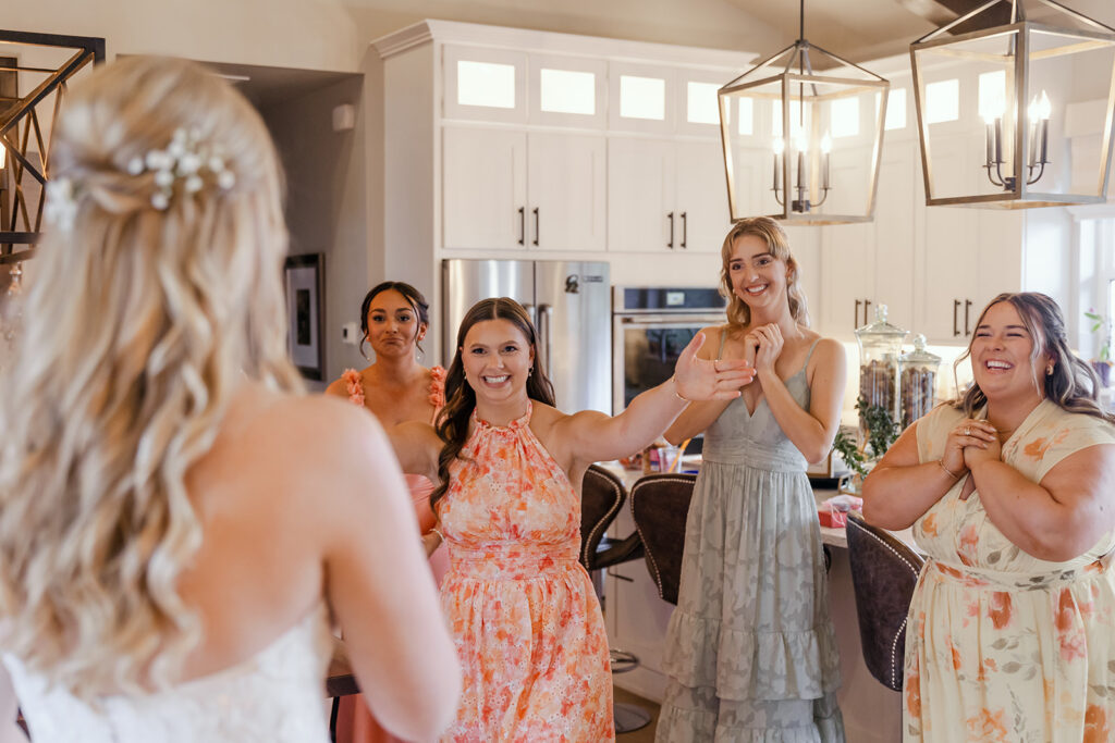 bridesmaids visible emotional seeing the bride wearing her wedding dress for the first time