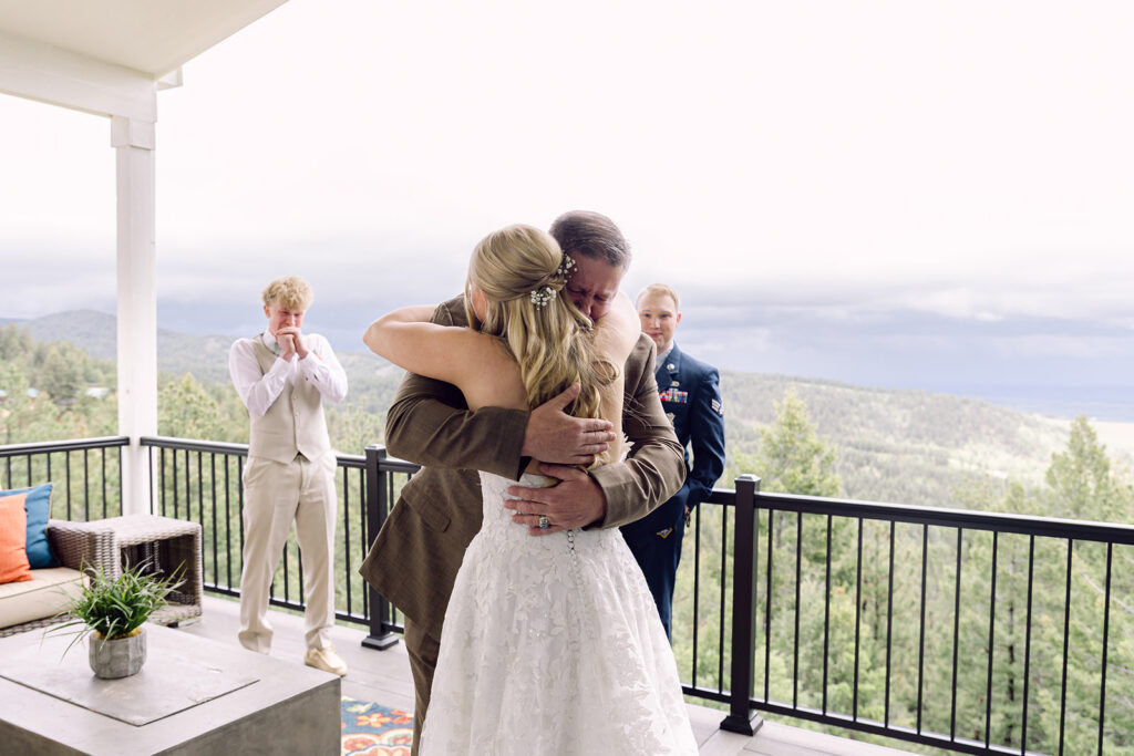 Father of the bride hugging her at the first look