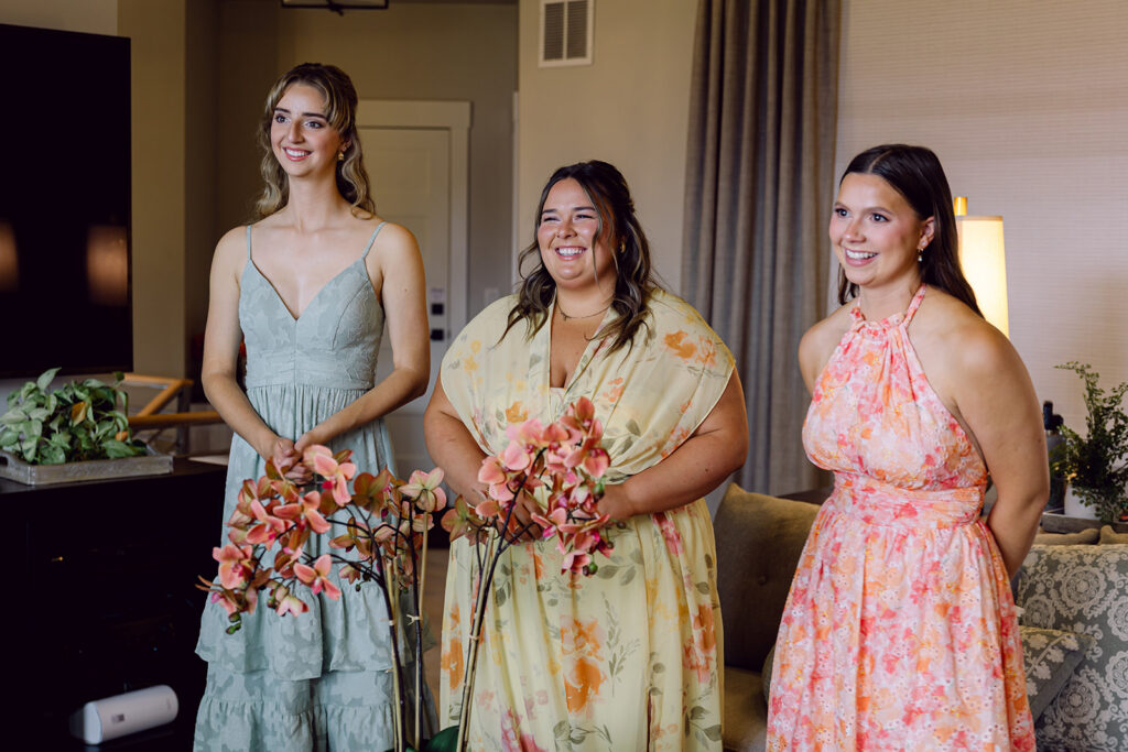 Bridesmaids observing the first look of the bride with her dad and brothers