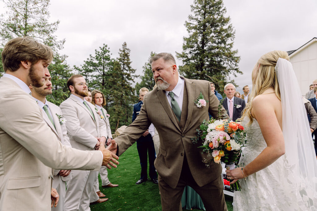 Father of the bride shaking hand to the groom at the altar