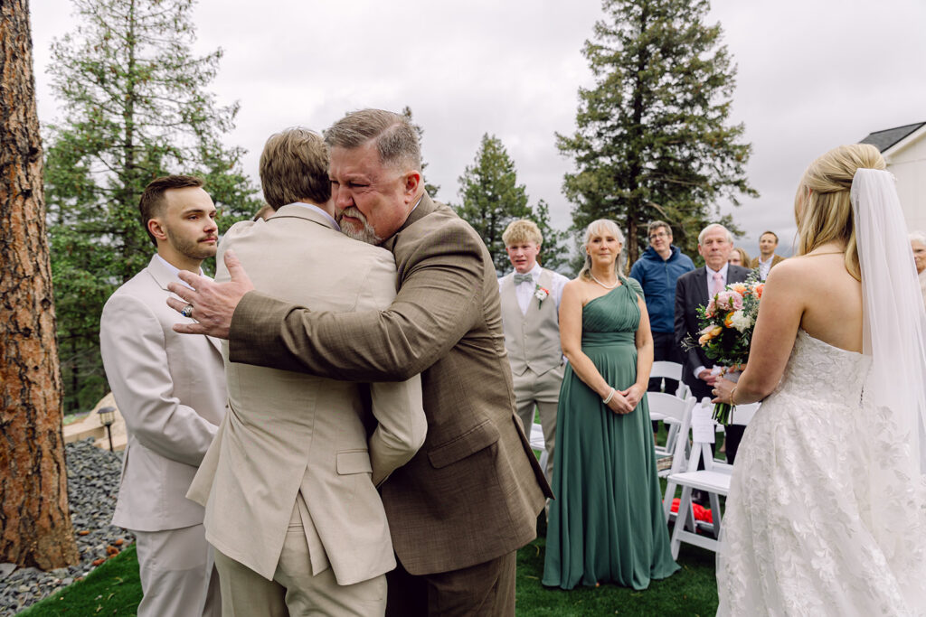 Father of the bride hugging the groom at the altar