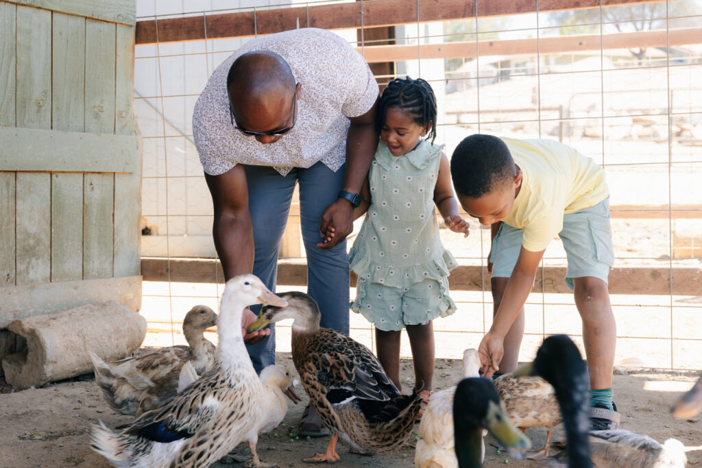 Family having fun feeding animals at The Happy Heart Haven Farm