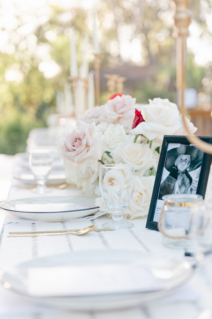 Table details close up to the flowers, frame with photo, plates and glasses